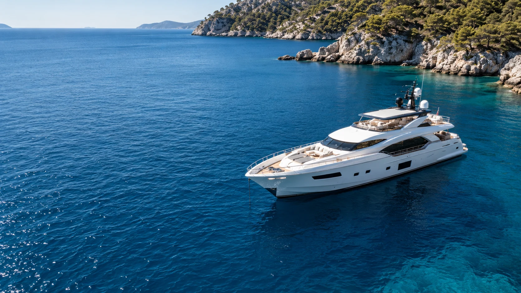Illustrative yacht at anchor in clear blue water